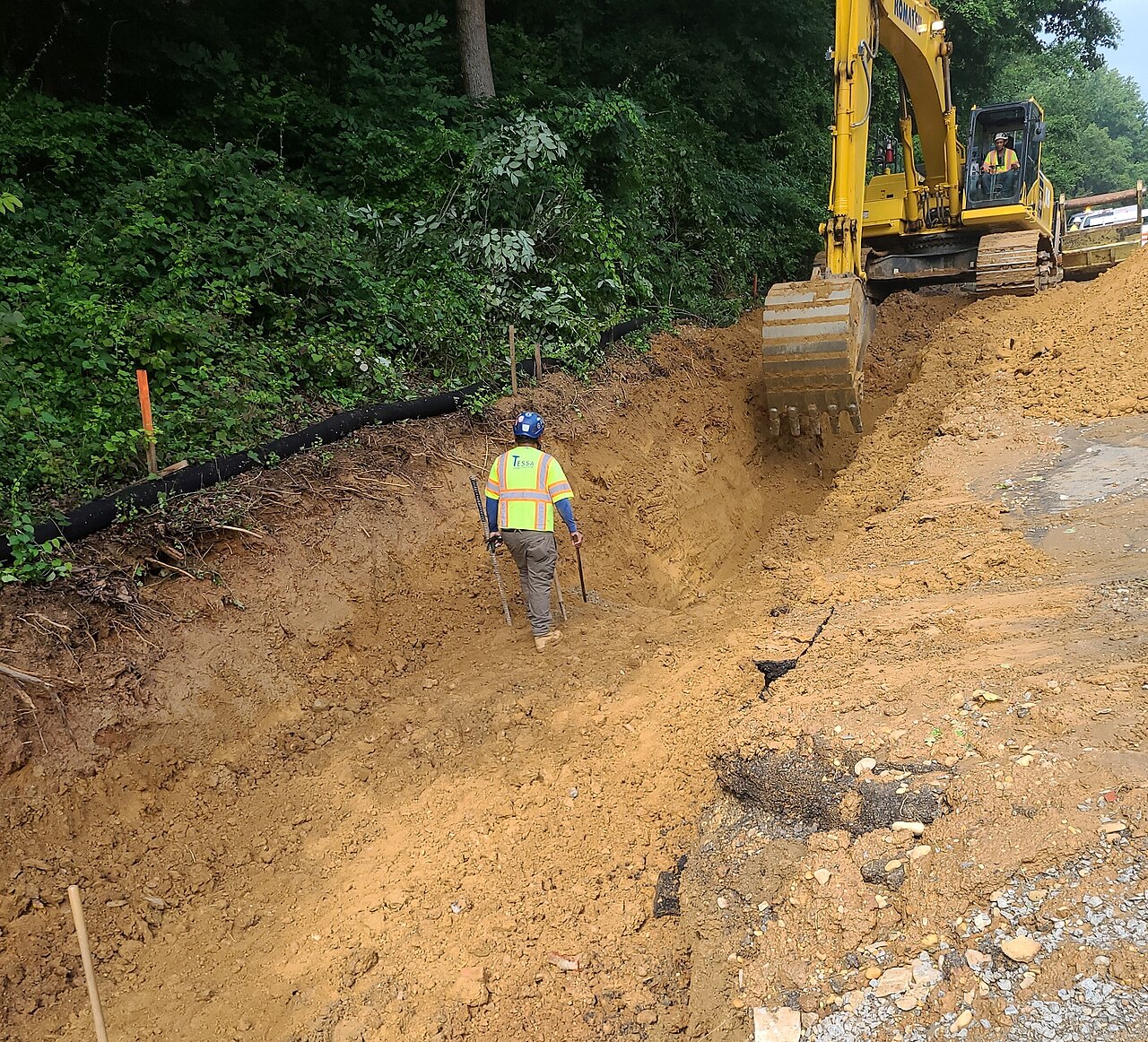 A construction worker near an excavator on the George Washington Memorial Parkway in 2023.